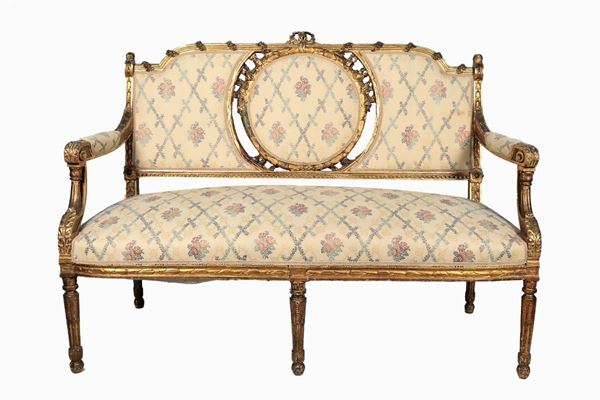 Divanetto francese Luigi XVI in legno dorato ed intagliato a rilievo a motivi di rose, calatine di fiori e foglie d'acanto
