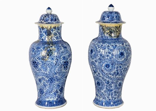 Coppia di antiche potiches cinesi in porcellana, con decorazioni in blu a motivi di fiori e foglie orientali