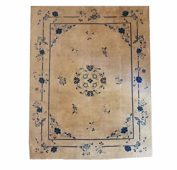 Tappeto cinese a fondo avana con bordo doppio stilizzato e rosone centrale con fiori blu, difetti e rapè, m 3,50 x 2,77