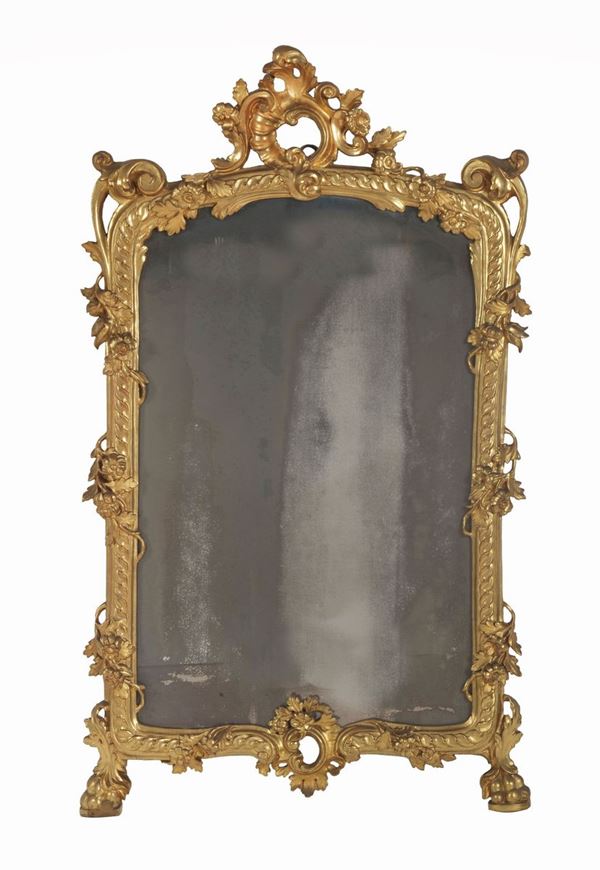 Specchiera romana Luigi XV in legno dorato, intagliato e scolpito con fregi a motivi di foglie d'acanto, conchiglia ed intrecci floreali, piedi a forma di zampa di leone e specchio al mercurio