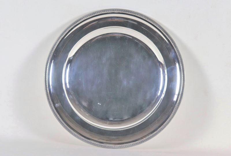 Grande piatto tondo da portata in argento, con bordo cesellato e sbalzato a motivi Impero, gr. 11...