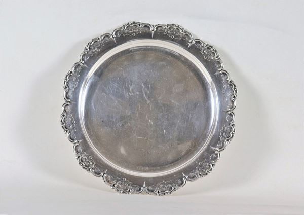 Piatto tondo in argento con bordo centinato, sbalzato e cesellato, gr. 510