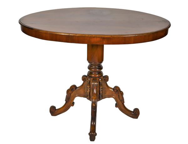 Louis Philippe oval coffee table in walnut, with faceted column base supported by four curved legs, defects on the top