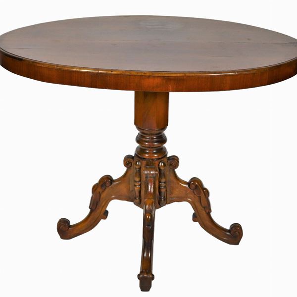 Tavolino ovale da centro Luigi Filippo in noce, con base a colonna sfaccettata sorretta da quattro gambe ricurve, difetti al piano