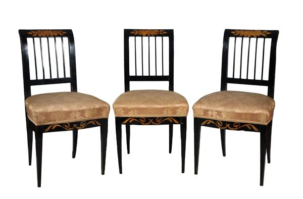 Lotto di tre antiche sedie in legno ebanizzato, con intarsi a motivi di intrecci floreali, schienali traforati e quattro gambe a piramide rovesciata. Copertura in tessuto avana 