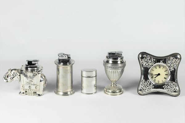 Four table lighters and a silver-coated clock