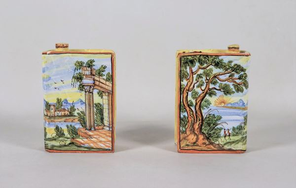 Coppia di piccole fiasche a forma di libro in maiolica smaltata di Pesaro, con decorazioni policrome dipinte a motivi di paesaggi