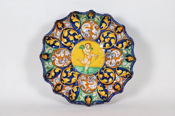 Crespina in glazed majolica from Faenza, painted and decorated in blue, orange and yellow with grotesque decorations and central putto