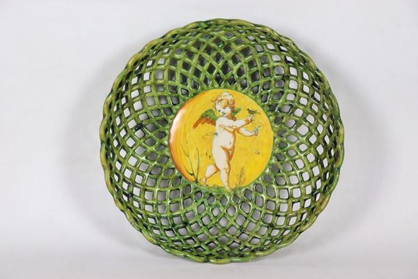Crespina in glazed Faenza majolica, in the shape of a perforated basket, with a putto in the center as a compendiary
