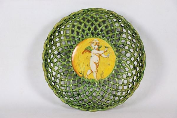 Crespina in maiolica smaltata di Faenza, a forma di cesto traforato, con al centro putto a compendiario