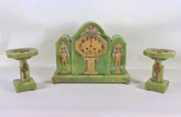 Art Nouveau triptych of a pendulum clock and two cup risers, in onyx marble and gilt bronze friezes