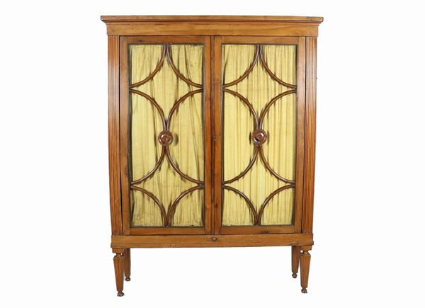 Walnut display cabinet with two glass doors with geometric patterned ferratelle, uprights and four fluted legs