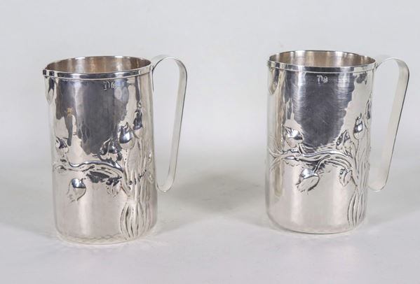 Pair of hammered silver water jugs with flowers in relief, gr. 950