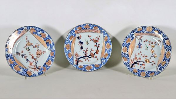 Lotto di tre piatti cinesi in porcellana Imari, con decorazioni in smalto blu, rosso e oro a motivi di alberi con fiori e uccelli esotici