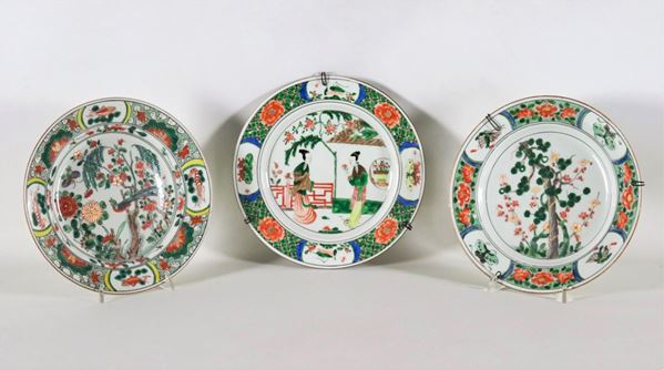 Lotto di tre piatti cinesi in porcellana "Famiglia Verde", con decorazioni variopinte a motivi di fiori, animali e scena familiare