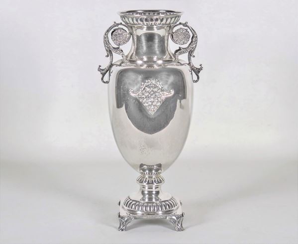 Anfora a due manici in argento, cesellata e sbalzata a motivi Impero, sorretta da quattro piedini ricurvi, gr. 670
