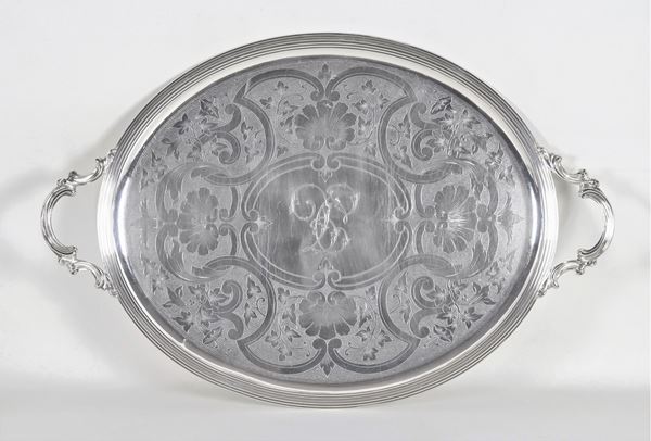 Grande vassoio francese ovale a due manici, in metallo argentato e sbalzato con fondo cesellato a volute floreali e conchiglie e monogramma al centro
