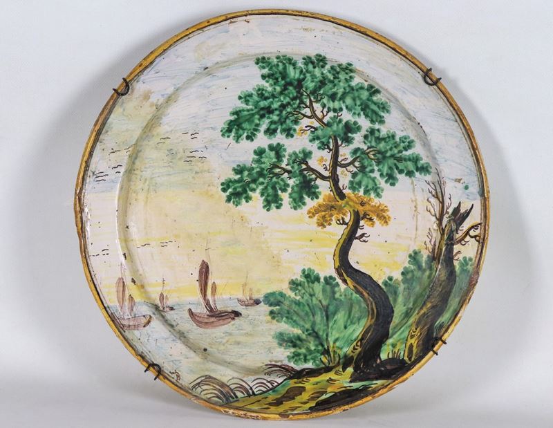 Piatto da parata in maiolica con decorazioni dipinte a motivo di "Marina con paesaggio". Restauri...