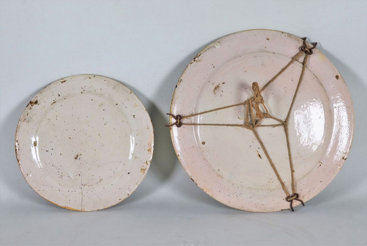 Lotto di due piatti in maiolica con decorazioni policrome a motivi di "Marine e paesaggi", uno gr...