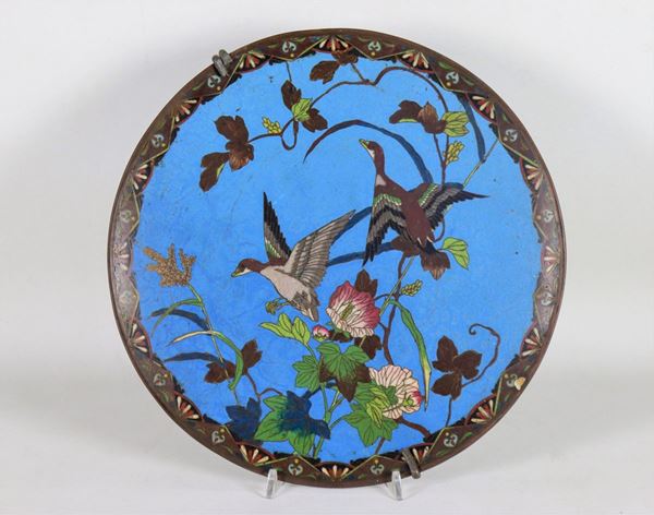 Cloisonné enamel plate with a blue background, with decorations in various enamels with "Birds and exotic flowers" motifs. In the back lack of polish on the edge
