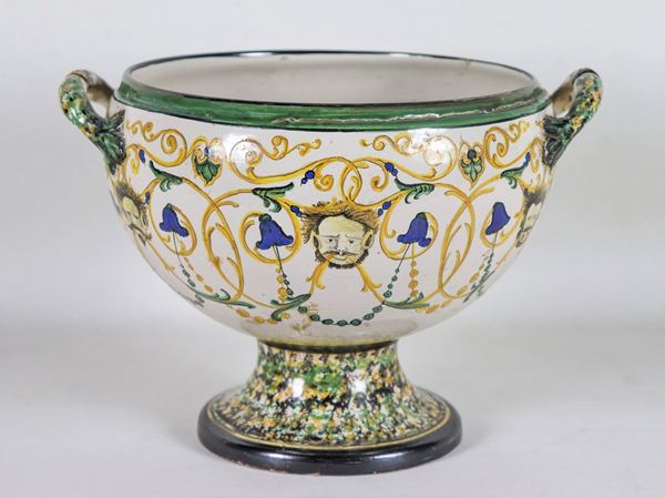 Round fruit bowl in glazed ceramic with relief decorations of scrolls, floral weaves and masks