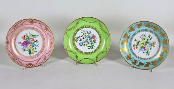 Lot of three wall plates in polychrome porcelain and pure gold, decorated with bunches of flowers
