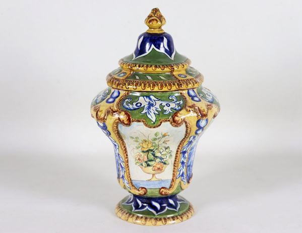 Amphora vase with lid, in glazed and polychrome majolica decorated with landscape motifs and vases with flowers