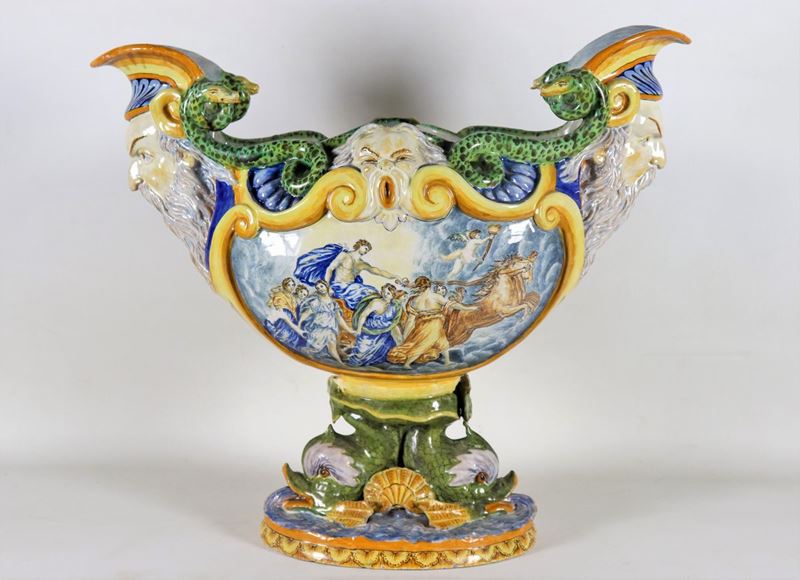 Grande centrotavola in maiolica smaltata policroma, con scene mitologiche, mascheroni, delfini e ...