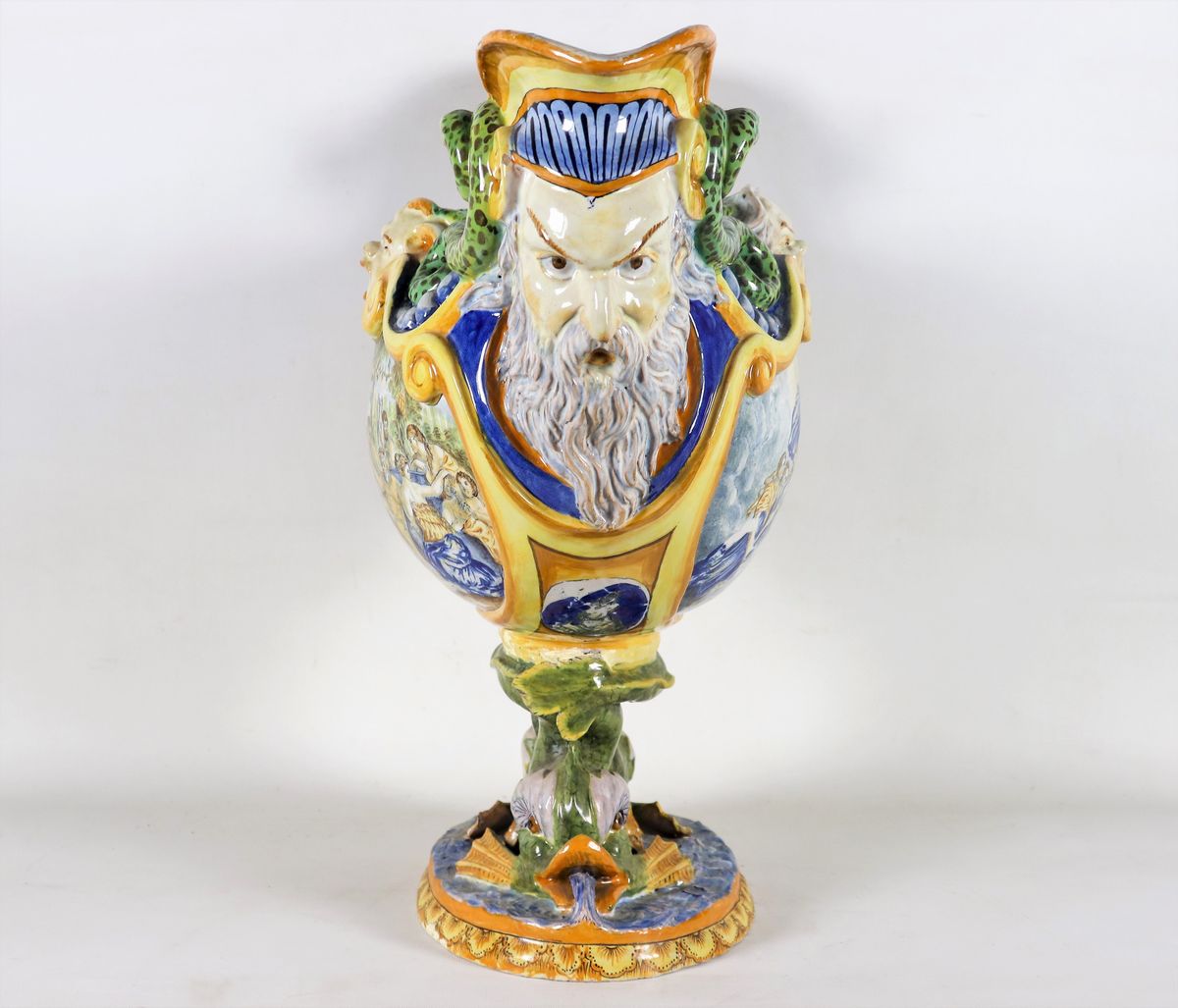 Grande centrotavola in maiolica smaltata policroma, con scene mitologiche, mascheroni, delfini e ...