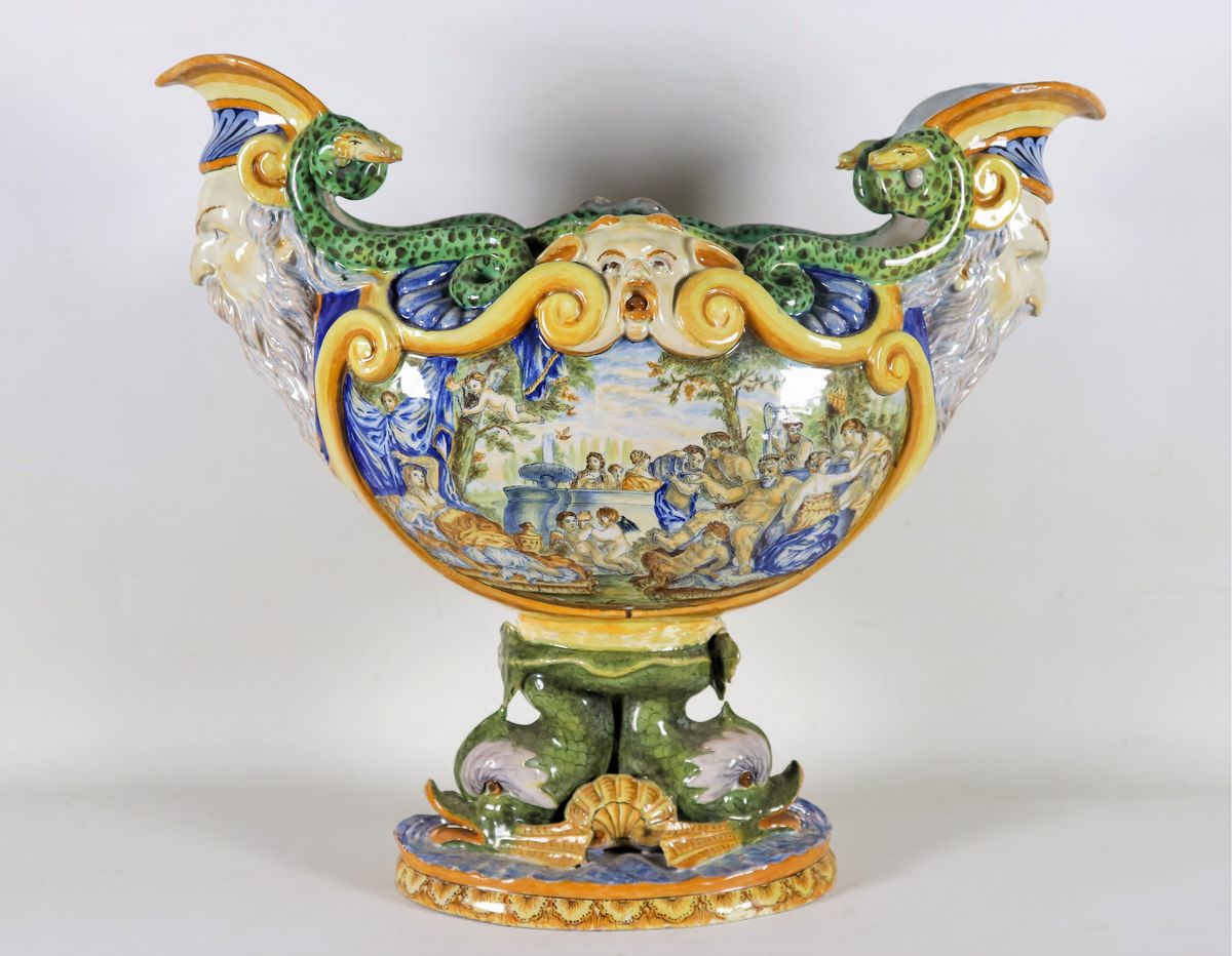 Grande centrotavola in maiolica smaltata policroma, con scene mitologiche, mascheroni, delfini e ...