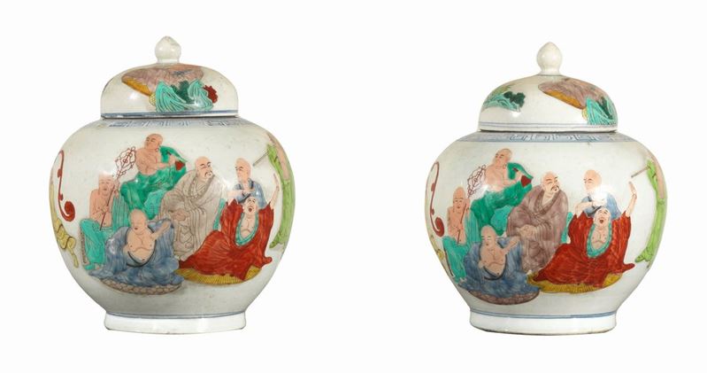 Coppia di grandi potiches con coperchi in porcellana, decorate con smalti policromi a rilievo con...