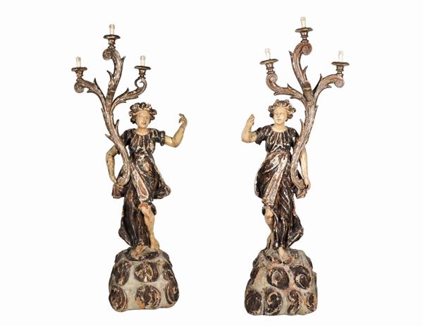 "Angeli", coppia di grandi sculture in legno intagliato e policromato, con riduzione a luce elettrica, tre luci ciascuna