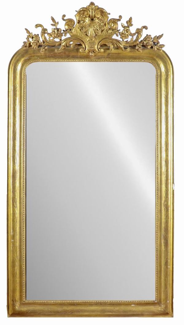 Mirror in gilded wood and grafito, with carved molding with motifs of volutes, flowers and shell, mercury mirror