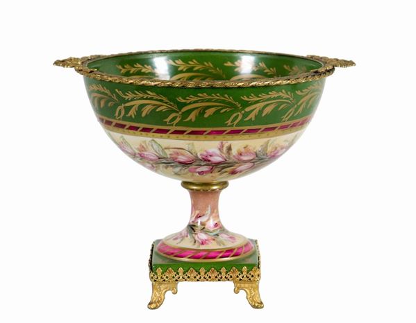 Coppa in porcellana francese di Limoges, con decorazioni variopinte di ghirlande floreali e fasce verdi e rosa, lumeggiature in oro zecchino e applicazioni in metallo dorato e cesellato