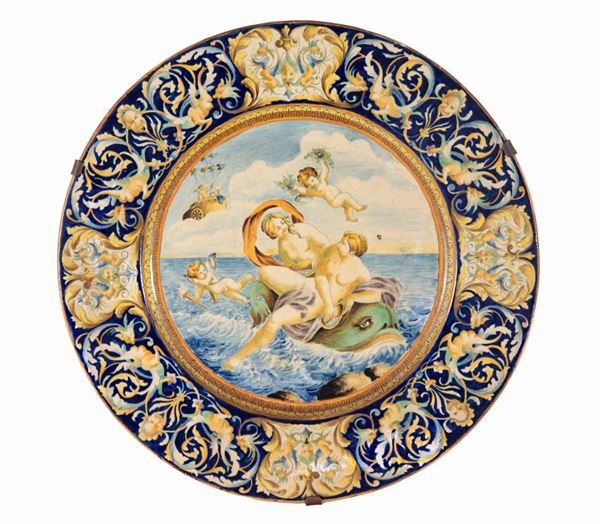 Grande piatto da parata in maiolica di Pesaro, interamente decorato e variopinto a motivi di intrecci floreali, mascheroni e "Scena mitologica" al centro