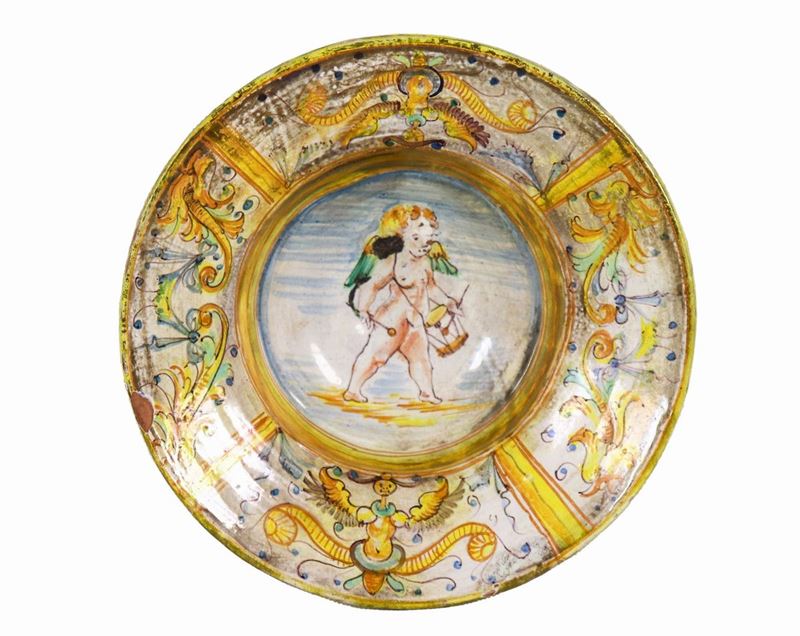 Antico piattino in maiolica italiana con decorazioni ad arabesche in giallo e celeste, al centro ...