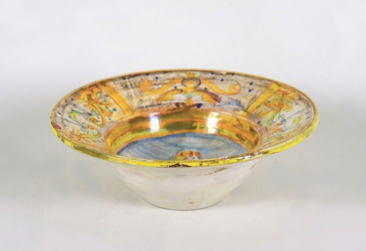 Antico piattino in maiolica italiana con decorazioni ad arabesche in giallo e celeste, al centro ...