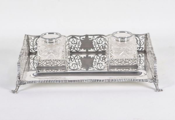 George V epoch inkwell, embossed, chiseled and perforated silver with two crystal bottles for ink, surrounded by a railing and supported by four lion feet, gr. 1360