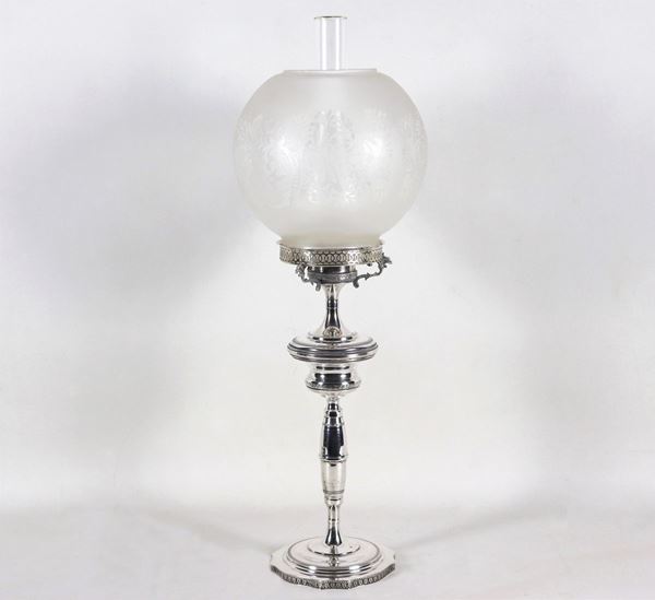 Candeliere in argento a forma di lampada a petrolio, cesellato e sbalzato a motivi Impero, globo in cristallo, gr. 340