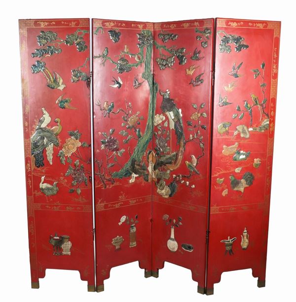 Chinese screen in red and black lacquer with relief decorations in various jades and semiprecious stones with birds, flowers and exotic plants motifs