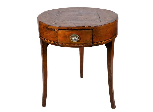 Round-shaped Lombard center table, in walnut and walnut briar with inlays with geometric motifs, a central pull-out with sliding shelf and three saber legs