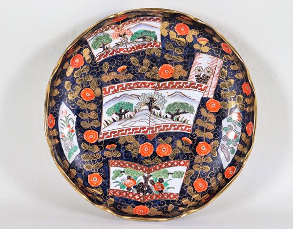 Chinese plate with arched edge in porcelain, entirely decorated with polychrome enamels in relief with motifs of landscapes and gilded exotic flowers