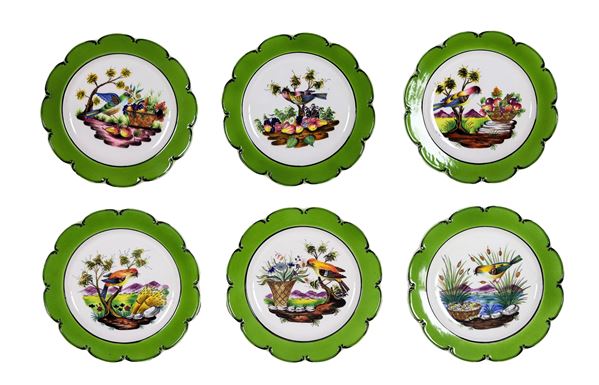 Lotto di sei piatti da muro in ceramica porcellanata e smaltata, con decorazioni policrome a rilievo a motivi di frutta e uccellini, bordi in verde