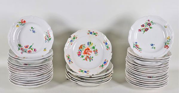 Lotto di 37 piatti in maiolica italiana porcellanata, con decorazioni in smalto a motivi di mazzetti di fiori