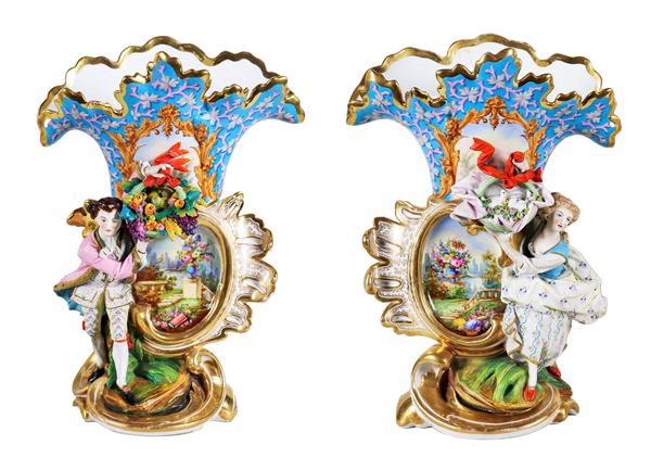 Pair of antique Louis Philippe "cartoccio" vases in porcelain, with relief sculptures "Lady and Knight", in the center medallions painted with landscape motifs and bunches of flowers, highlights in pure gold