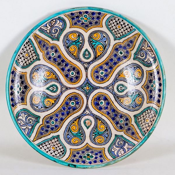 Large oriental round plate in porcelain and glazed ceramic, entirely decorated and colorful in relief with oriental motifs