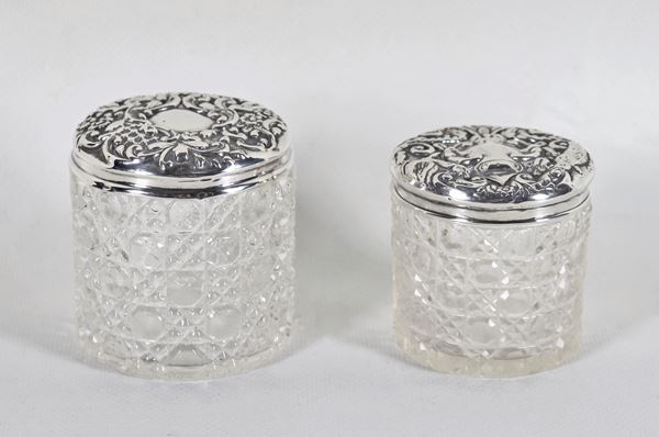 Lotto di due piccoli flaconi da toletta in cristallo lavorato, con coperchi in argento sbalzato e cesellato
