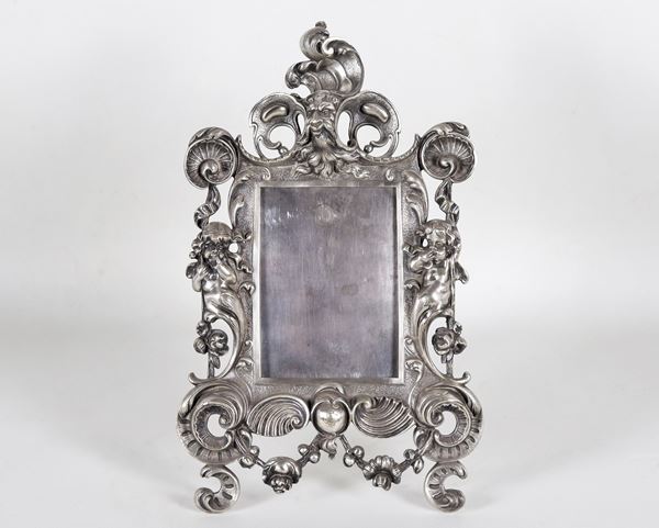 Antique table photo frame in silvered bronze, embossed and chiseled with Louis XIV motifs, with cherubs, mask and shells