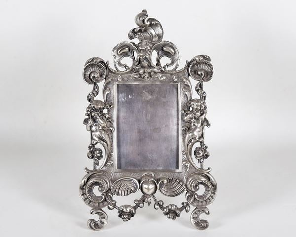 Antica cornice portafoto da tavolo in bronzo argentato, sbalzato e cesellato a motivi Luigi XIV, con putti, mascherone e conchiglie