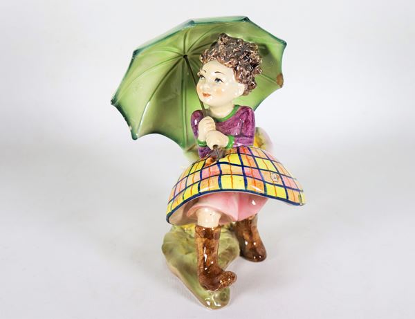 Piccola scultura "Bambina con ombrello" in maiolica smaltata e porcellanata